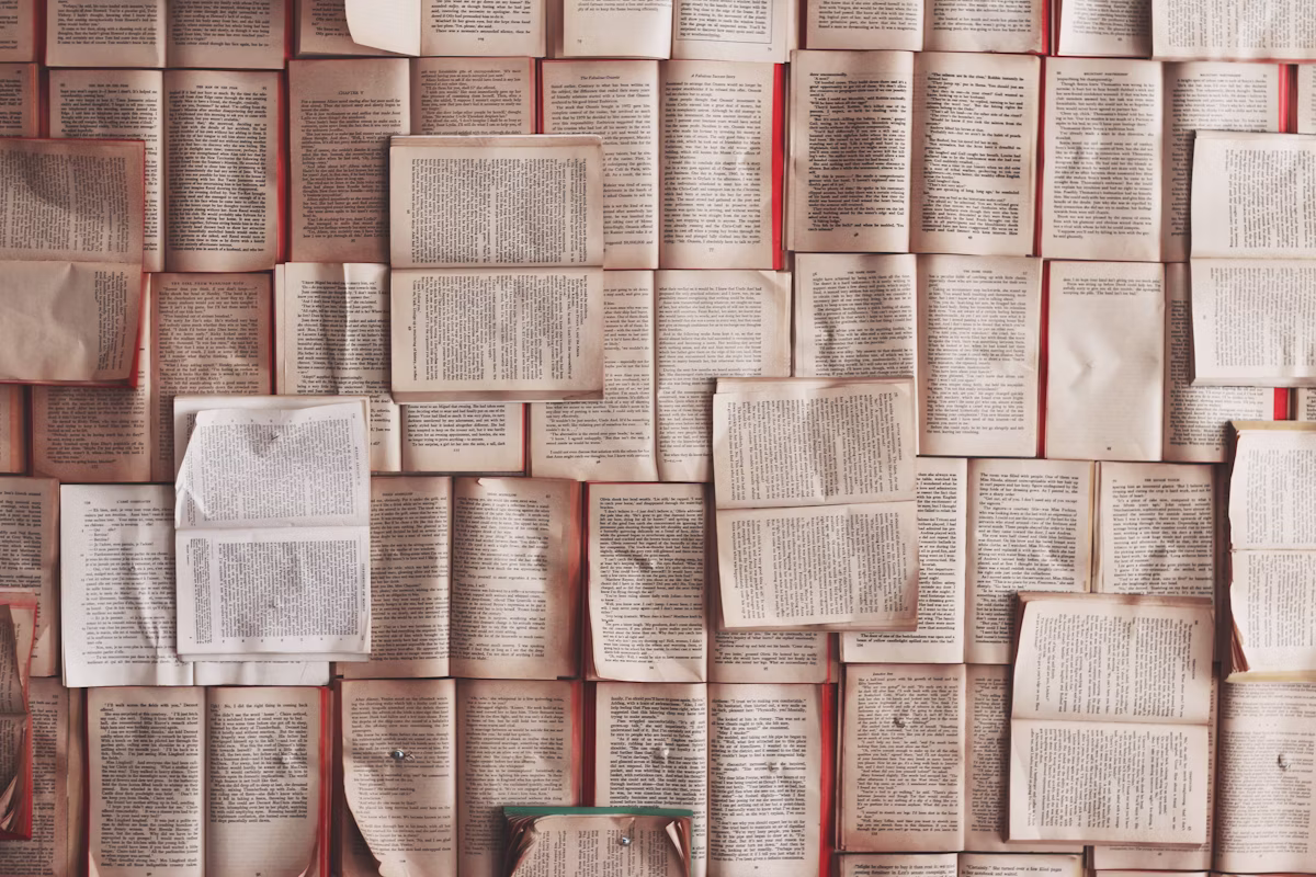Collection of open books arranged with visible pages, creating a literary background that represents reading, knowledge, and education.